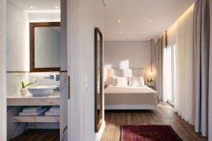una camera bianca con letto e specchio di Kappa Resort a Paliouri