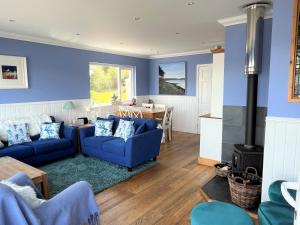 uma sala de estar com paredes azuis e sofás azuis em Craignethan em Kames