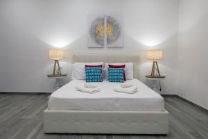 a bedroom with a large white bed with two lamps at Domus Federiciana in Castellammare del Golfo +58 photos