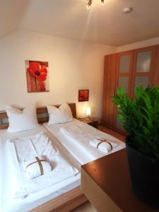 1 Schlafzimmer mit 2 Betten mit weißer Bettwäsche und einer Pflanze in der Unterkunft Winterberg Appartement 21098 in Winterberg