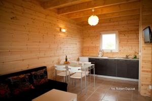 a room with a kitchen and a table in a room at Domki Letniskowe Blue Sky 1 in Rewal