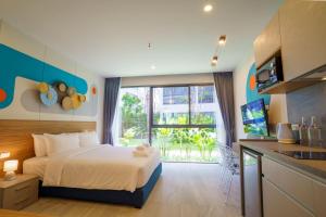 um quarto com uma cama e uma grande janela em HOMA Phuket Town em Phuket