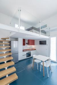 uma cozinha branca com uma mesa e uma escada em EGIDA camere mediterranee em Favignana