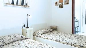 ein Schlafzimmer mit 2 Betten und einer Lampe auf einem Nachttisch in der Unterkunft La Casa di Rosa in Rio Marina