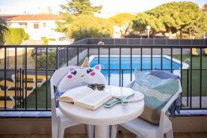 ein Tisch mit einem Buch auf einem Balkon mit einem Tisch mit einem Tisch in der Unterkunft RVApartaments Tropic in L'Estartit