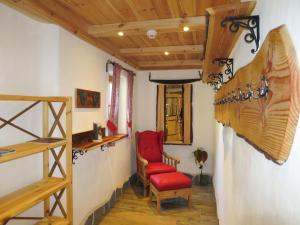 Habitación con silla roja y escalera en Chalet Aualm - FRT101 by Interhome en Forstau