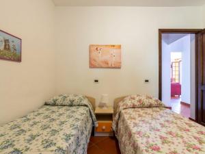 サン・ロレンツォ・アル・マーレにあるHoliday Home Nicolò by Interhomeのベッド2台、テーブル、写真が備わる客室です。