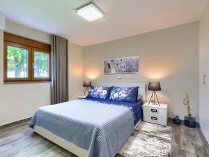 a bedroom with a bed with a blue comforter at Holiday Home Sara - KST251 by Interhome in Tar