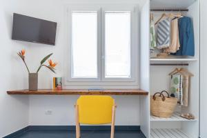 a yellow chair sits at a desk in a room at EGIDA camere mediterranee in Favignana