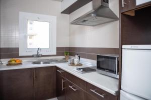 cocina con fregadero y microondas en RVHotels Apartamentos Tropic, en L'Estartit
