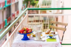a table with a plate of fruit and cups on it at Il Tempio di Athena - Cultura e Relax a Siracusa in Siracusa