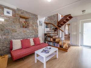 - un salon avec un canapé rouge et un mur en pierre dans l'établissement Holiday Home Le Mura by Interhome, à Cividale del Friuli