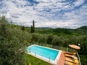 una piscina al aire libre con sombrilla y árboles en Holiday Home Colle alla luna by Interhome en Pieve a Nievole