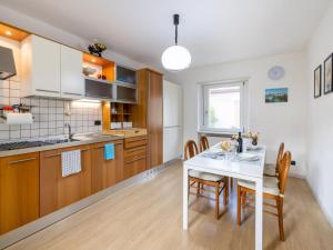 a kitchen with a white table and wooden cabinets at Holiday Home Le Mura by Interhome in Cividale del Friuli +32 photos