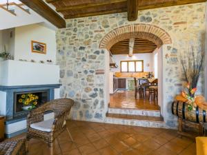 un soggiorno con parete in pietra e camino di Holiday Home Poggio all'Aia by Interhome a Lucciana