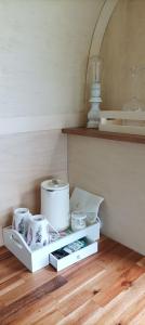 une étagère blanche avec de la vaisselle sur le parquet dans l'établissement Camping Les Ronds Duval face aux îles anglo-normandes, à Les Moitiers-dʼAllonne