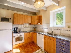 uma cozinha com armários de madeira e um frigorífico branco em Holiday Home Pen Ilis by Interhome em Saint-Jean-Trolimon