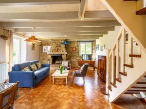 a living room with a blue couch and a table at Holiday Home Pen Ilis by Interhome in Saint-Jean-Trolimon