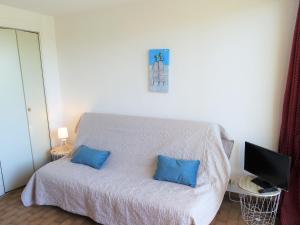 um quarto com uma cama com duas almofadas azuis em Apartment Les Logis du Languedoc by Interhome em Gruissan