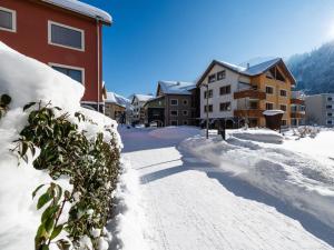 una strada ricoperta di neve accanto agli edifici di Apartment TITLIS Resort 3-Zimmer Wohnung 8 by Interhome a Engelberg