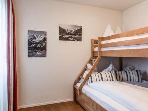 ein Schlafzimmer mit einem Etagenbett und zwei Bildern an der Wand in der Unterkunft Apartment TITLIS Resort 3-Zimmer Familienwohnung 2 in Engelberg