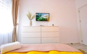 a bedroom with a bed and a dresser at SOFIA Cozy Apartment - Underground Private Parking in Bucharest