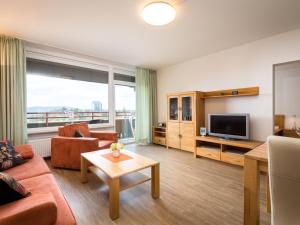 ein Wohnzimmer mit einem Sofa und einem TV in der Unterkunft Apartment A1208 by Interhome in Lahnstein