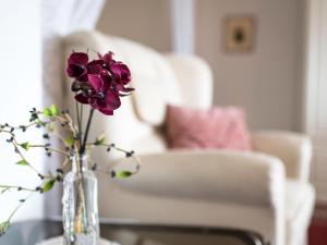 a vase with purple flowers on a table with a chair at Apartment A905 by Interhome in Lahnstein