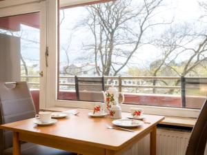 einen Tisch mit Tassen und Untertassen und ein Fenster in der Unterkunft Apartment B306 by Interhome in Lahnstein