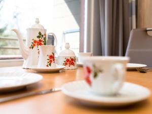 a wooden table with tea cups and saucers on it at Apartment B306 by Interhome in Lahnstein