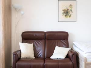 a brown leather chair with two white pillows on it at Apartment B306 by Interhome in Lahnstein