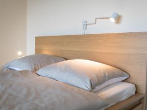a bed with two pillows and a light above it at Apartment B807 by Interhome in Lahnstein