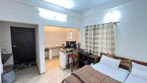 a living room with a bed and a desk with a computer at Goshen Inn in Bangalore