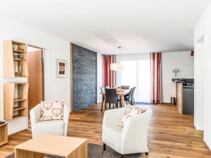 a living room with two chairs and a table at Apartment TITLIS Resort 3-Zimmer Wohnung 5 by Interhome in Engelberg