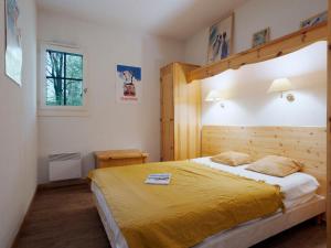 1 dormitorio con 1 cama grande con colcha amarilla en Apartment Le Grand Panorama-1 by Interhome, en Saint-Gervais-les-Bains