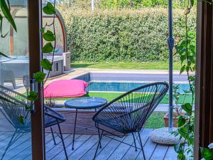 a patio with a table and chairs next to a pool at Holiday Home Blue Moustoir by Interhome in Carnac