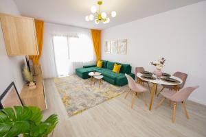 a living room with a green couch and a table at SOFIA Cozy Apartment - Underground Private Parking in Bucharest