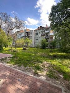 un grand bâtiment avec un parc en face dans l'établissement Котляревського апартамент з садом, à Lviv