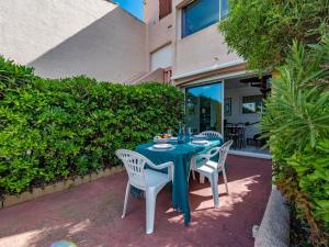 a blue table and chairs on a patio at Holiday Home Nautica-3 by Interhome in Le Barcarès +30 photos
