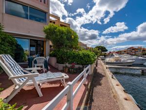 une maison avec un banc et des bateaux dans l'eau dans l'établissement Holiday Home Nautica-3 by Interhome, au Barcarès