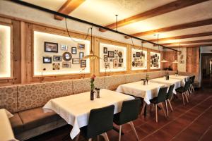 una fila de mesas en un restaurante con mantel blanco en Fischerwirt am See en Achenkirch