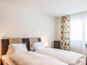 twee bedden in een kamer met een raam bij Apartment TITLIS Resort 4-Zimmer Wohnung 1 by Interhome in Engelberg