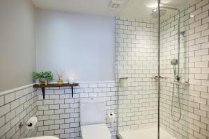 uma casa de banho com um WC e uma cabina de duche em vidro. em The Red Lion em Odiham