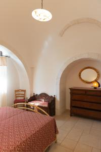 um quarto com uma cama, uma cómoda e um espelho em Trullo Magnolia em Ostuni