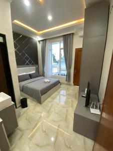 a bedroom with a king sized bed and a television at Algara Puncak Hotel in Puncak
