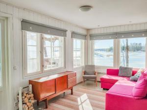 uma sala de estar com mobiliário rosa e janelas em Holiday Home Långahuset by Interhome em Västlax