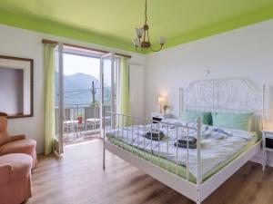 1 dormitorio con 1 cama y balcón en Apartment Casa Rosalia by Interhome, en Agarone