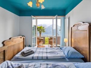 1 dormitorio con 1 cama y vistas a un balcón en Apartment Casa Rosalia by Interhome, en Agarone
