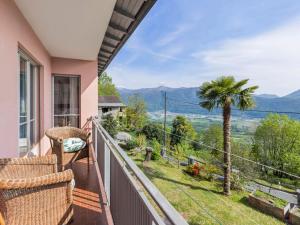 balcón con vistas a una palmera y a las montañas en Apartment Casa Rosalia by Interhome, en Agarone
