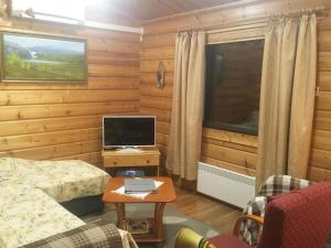 ein Schlafzimmer mit einem Bett und einem Schreibtisch mit einem Fernseher in der Unterkunft Holiday Home Metso-pirtti by Interhome in Saariselkä